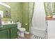 Bathroom with green vanity, patterned wallpaper, and white bathtub at 771 Flowering Branch Ave., Little River, SC 29566