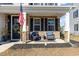 Relaxing front porch with seating and American flag at 771 Flowering Branch Ave., Little River, SC 29566