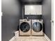 Laundry room with modern washer and dryer, dark walls, and white cabinets at 771 Flowering Branch Ave., Little River, SC 29566