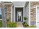 Inviting front entry with a glass paneled door, flanked by stone and siding, enhancing the home's exterior at 912 Lorenzo Dr., North Myrtle Beach, SC 29582