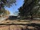A spacious backyard featuring mature trees, a well-maintained lawn, and a view of the home's exterior at 10 Buckthorn St., Andrews, SC 29510