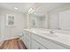 Bright bathroom features a double sink vanity, large mirror, and wood-look flooring at 112 Lakota Loop, Longs, SC 29568