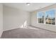 Bright bedroom with neutral carpet, white trim, light-colored walls, and a view to the outside at 112 Lakota Loop, Longs, SC 29568
