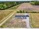 Aerial view of home with gravel driveway, covered storage, and agriculture field at 122 Willie Mays Pl., Aynor, SC 29511