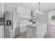 Bright kitchen with island, stainless steel appliances, white cabinets, and a view into the mudroom at 122 Willie Mays Pl., Aynor, SC 29511