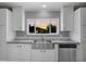 Close-up of the kitchen sink with white cabinets and a window overlooking the outdoors at sunset at 122 Willie Mays Pl., Aynor, SC 29511