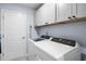 Laundry room with white washer and dryer and gray cabinets at 1420 Jardine Loop, Little River, SC 29566