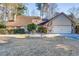 House exterior features stone accents, a two-car garage, and a well-maintained lawn at 1751 Gibson Ave., Surfside Beach, SC 29575