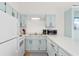 Galley kitchen with teal cabinets, white appliances, and a double sink at 1851 Colony Dr. # 5E, Surfside Beach, SC 29575