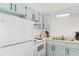 White appliances and teal cabinets in a galley kitchen at 1851 Colony Dr. # 5E, Surfside Beach, SC 29575