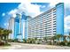 Oceanfront Caribbean Resort & Villas building, showcasing its blue and white exterior and palm trees at 3000 N Ocean Blvd. # 333, Myrtle Beach, SC 29577