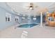 Indoor pool with ceiling fan and windows at 4552 River Rd., Little River, SC 29566