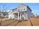 Gray siding two-story house with white trim, landscaping, and a covered porch at 5023 Sweet Birch Lane, Conway, SC 29526