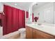 Clean bathroom with a burgundy shower curtain and wood vanity at 648 Twinflower Dr., Little River, SC 29566