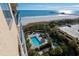 Aerial view showcasing ocean, a pier, pool, and manicured greenery with lounge chairs at 8560 Queensway Blvd. # 706, Myrtle Beach, SC 29572