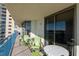 Condo balcony featuring green Adirondack chairs and small tables overlooking the ocean at 8560 Queensway Blvd. # 706, Myrtle Beach, SC 29572