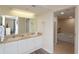 Bright bathroom featuring double sinks with a neutral granite counter and a large vanity mirror at 8560 Queensway Blvd. # 706, Myrtle Beach, SC 29572