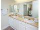 Bright bathroom featuring double sinks with a neutral granite counter and a large vanity mirror at 8560 Queensway Blvd. # 706, Myrtle Beach, SC 29572