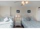 Bedroom featuring two beds, matching bedside tables, lamps, seascape art and ceiling fan at 8560 Queensway Blvd. # 706, Myrtle Beach, SC 29572