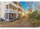 Condo back exterior with multiple floors featuring screened-in porches on each level and view of pathway at 1100 Possum Trot Rd. # H234, North Myrtle Beach, SC 29582