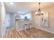 Bright kitchen features white cabinets, stainless steel appliances, granite counters, and a dining area with modern chandelier at 1100 Possum Trot Rd. # H234, North Myrtle Beach, SC 29582