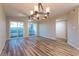 Spacious living room with wood floors, a ceiling fan, and sliding glass doors leading to a balcony with water views at 1100 Possum Trot Rd. # H234, North Myrtle Beach, SC 29582