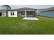 Back exterior view with a screened patio area, and a spacious green lawn, great for outdoor enjoyment at 1305 Crested Iris Way, North Myrtle Beach, SC 29582