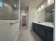 Modern bathroom with double vanity, grey tile flooring, and a glass-enclosed shower, creating a spa-like retreat at 1305 Crested Iris Way, North Myrtle Beach, SC 29582