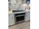 Kitchen features stainless steel oven, cooktop, and range hood with white cabinets and countertops at 1310 Beautyberry Way, North Myrtle Beach, SC 29582