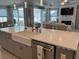 Bright kitchen boasts a large island with white countertops, farmhouse sink, and modern appliances at 1310 Beautyberry Way, North Myrtle Beach, SC 29582