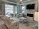 Relaxing living room with a fireplace, comfortable seating, and natural light from sliding glass doors leading to a sunroom at 1310 Beautyberry Way, North Myrtle Beach, SC 29582