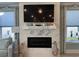 Cozy living room features a fireplace with coastal decor and sconce lighting with natural light from two large windows at 1310 Beautyberry Way, North Myrtle Beach, SC 29582