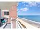 Balcony with chair offers beach view on sunny day with blue sky and ocean at 2701 S Ocean Blvd. # 1711, North Myrtle Beach, SC 29582