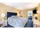 Relaxing bedroom with yellow walls, blue carpet, a queen bed, and an ensuite bathroom at 2701 S Ocean Blvd. # 1711, North Myrtle Beach, SC 29582