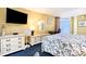 Bedroom with yellow walls, blue carpet, queen bed, TV, dresser, and sliding glass door to balcony at 2701 S Ocean Blvd. # 1711, North Myrtle Beach, SC 29582