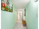 Light green hallway featuring tiled floors and decorative wall art, leading to other rooms at 2701 S Ocean Blvd. # 1711, North Myrtle Beach, SC 29582