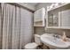 Clean bathroom with a white sink, toilet and shower. Gray walls and a white cabinet at 400 N Waccamaw Dr. # 304, Garden City Beach, SC 29576