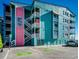 Seawatch VII building exterior, teal and pink, with parking and ocean view at 400 N Waccamaw Dr. # 304, Garden City Beach, SC 29576