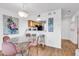 Bright dining area with glass-top table, pink chairs, and kitchen bar at 4560 Greenbriar Dr. # 102-B, Little River, SC 29566