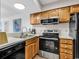 Updated galley kitchen features modern appliances, oak cabinets and neutral countertops at 4560 Greenbriar Dr. # 102-B, Little River, SC 29566