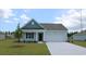 Charming one-story home with light blue siding, a white garage door, and a landscaped lawn at 528 Duvall St., Longs, SC 29568