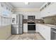 Bright kitchen with stainless steel appliances, white cabinets, and tiled backsplash at 618 3Rd Ave. S # 4D, North Myrtle Beach, SC 29582