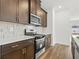 Kitchen boasts stainless steel appliances and dark wood cabinets at 847 Cypress Preserve Circle, Longs, SC 29568