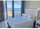 Bright bedroom with white furniture and a large window showcasing ocean views at 9550 Shore Dr. # 1226, Myrtle Beach, SC 29572