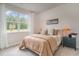 Well-lit bedroom with a tan comforter, nightstands, and large window at 1129 Black Lake Way, Conway, SC 29526