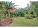 Landscaped backyard with lush greenery, a pergola, and garden at 113 Meeting St., Georgetown, SC 29440