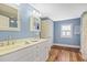 Light blue bathroom with white vanity and hardwood floors at 113 Meeting St., Georgetown, SC 29440