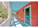 Bright teal porch with red home exterior and tree views at 113 Meeting St., Georgetown, SC 29440