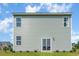 Rear view of a two-story house with light green siding and a sliding glass door at 1457 Nokota Dr., Conway, SC 29526