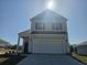 Two-story house with light beige vinyl siding, a white garage door, and a landscaped front yard at 1489 Nokota Dr., Conway, SC 29526